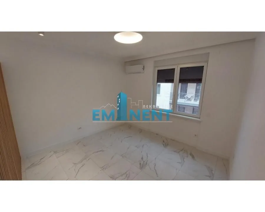Empty bright room with white walls and marble tile flooring.