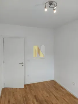 Prazna soba sa belim zidovima, drvenim podom i zatvorenim vratima. - image 11
