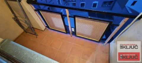 Manji popločani balkon sa metalnom ogradom i pogledom na zgradu. - image 11