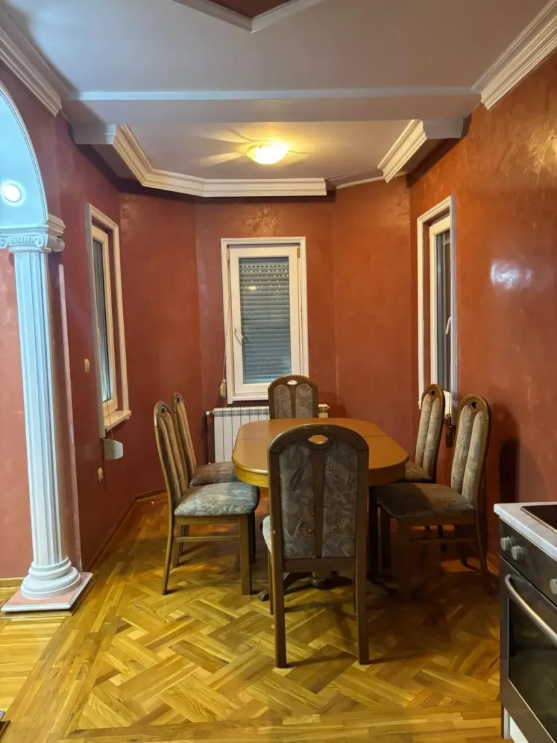Dining area with a wooden table and chairs in a room with red walls.