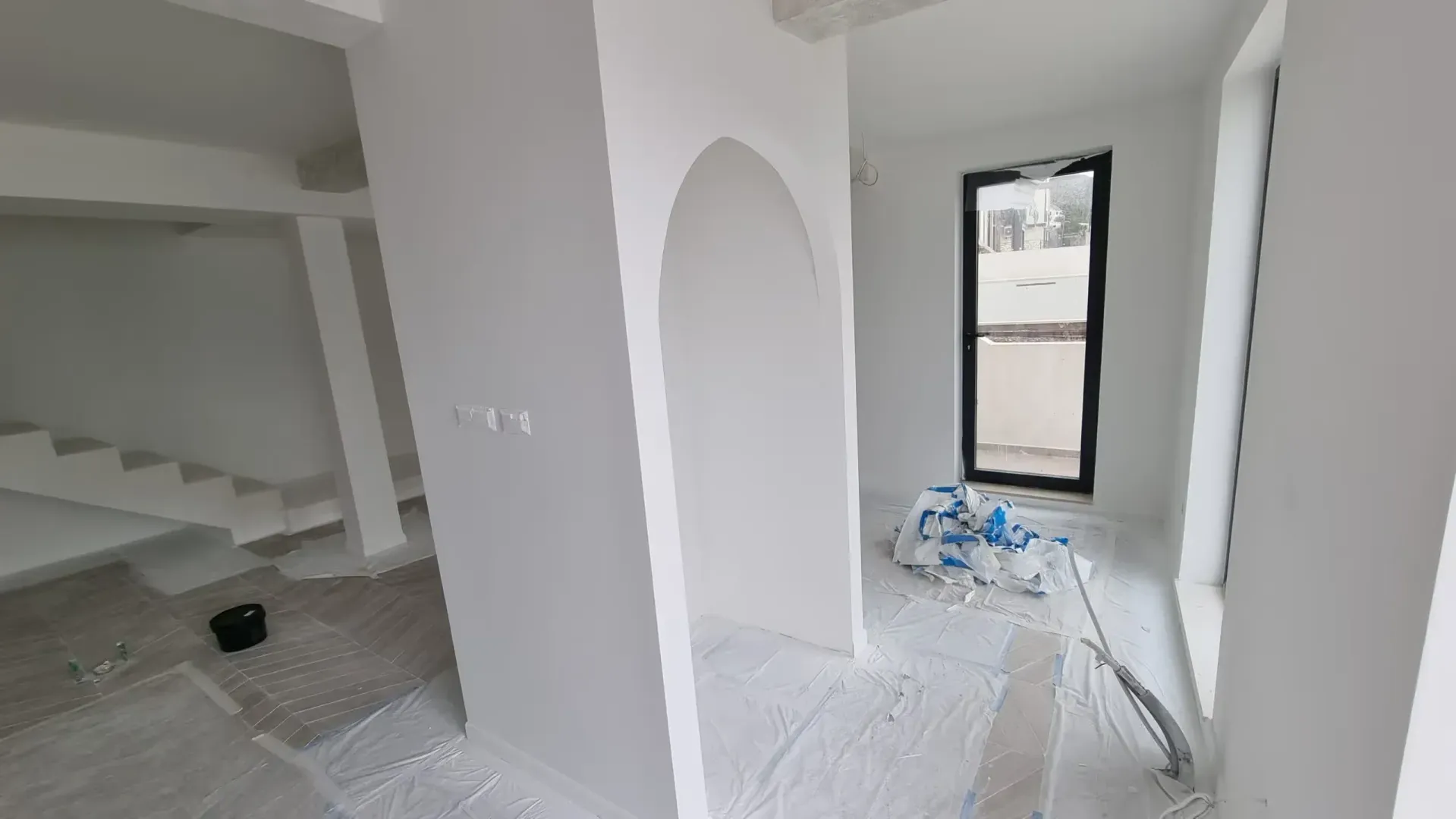 Unutrašnjost nenamještenog prostora u fazi renoviranja sa zaštitnom folijom na podu.