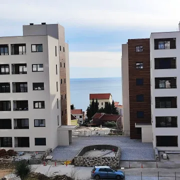 Pogled na zgrade i more između njih sa uređenim dvorištem u prvom planu. - image 5
