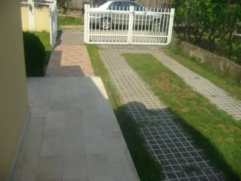 Dvorište sa popločanom stazom i bijelom kapijom. - image 2