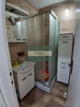 Manje kupatilo sa tuš kabinom, umivaonikom i belim kupatilskim nameštajem. - image 10