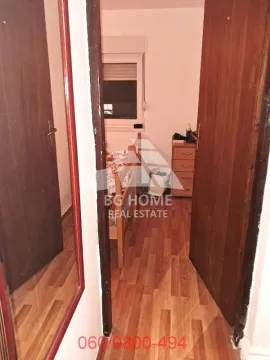 Pogled iz hodnika u spavaću sobu sa drvenim krevetom i komodom. - image 8