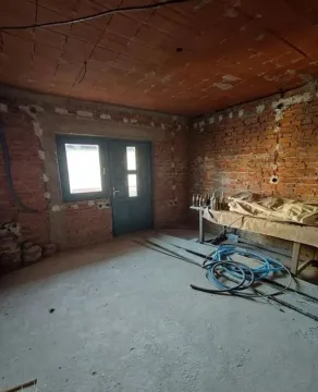 Nepotpuna prostorija u fazi renoviranja sa ciglenim zidovima i betonskim podom. - image 17