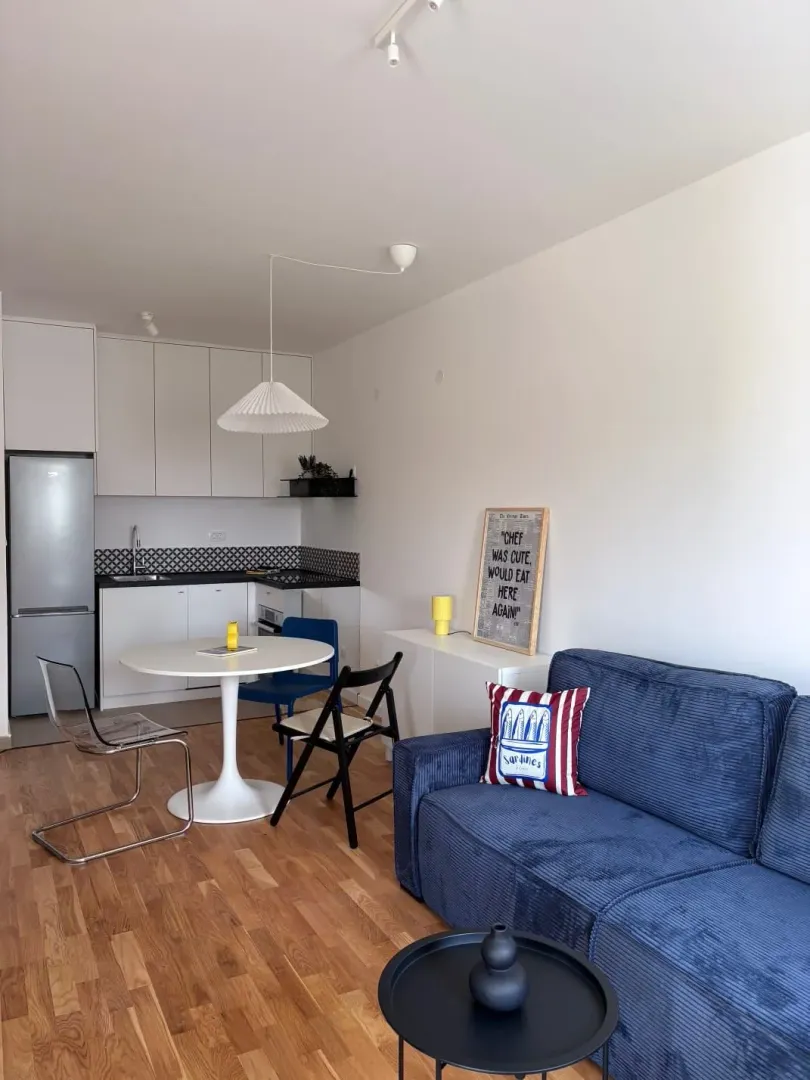 Modern living room with kitchen and dining area.