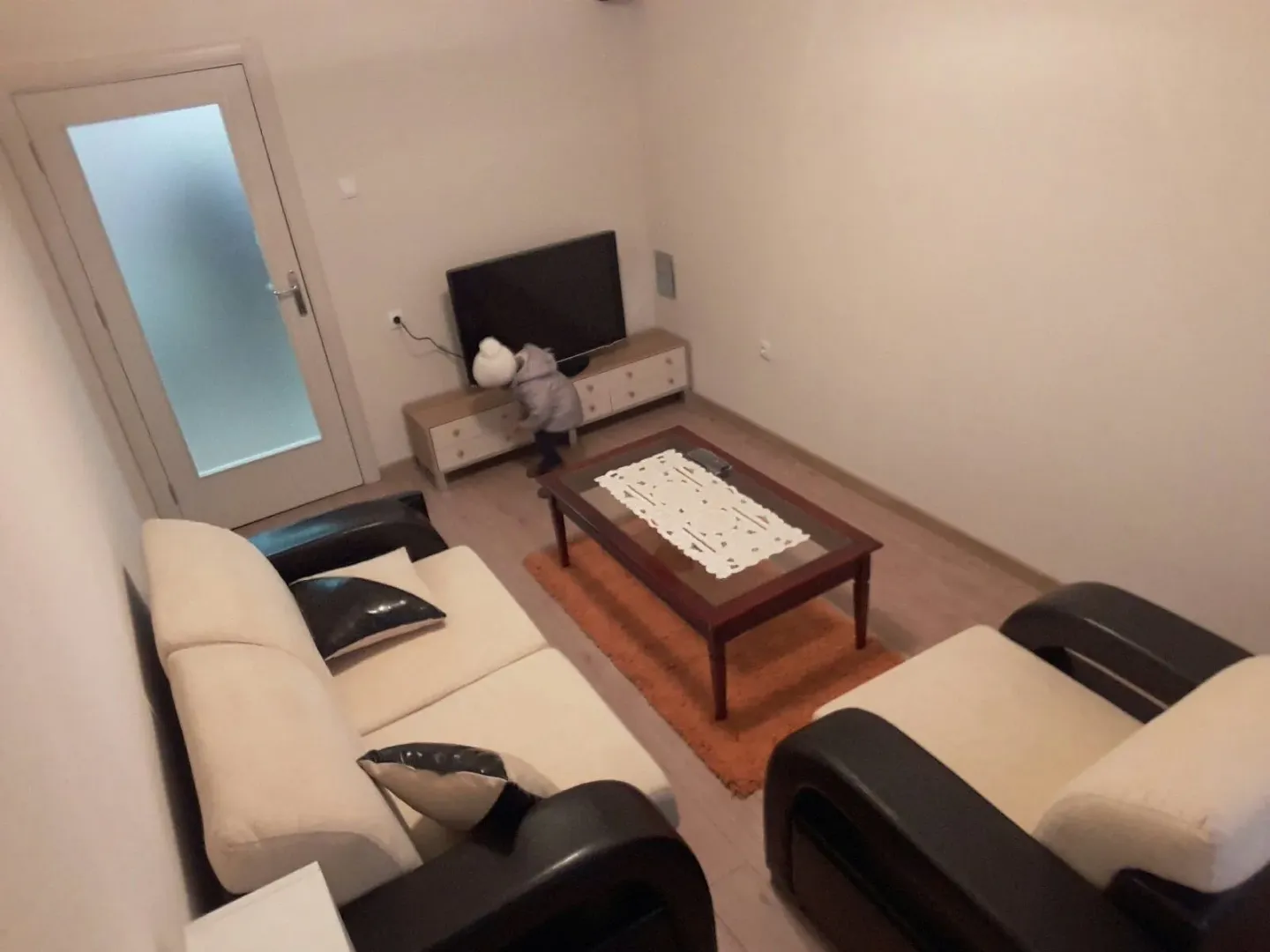 Simple living room with a sofa, armchair, and coffee table.