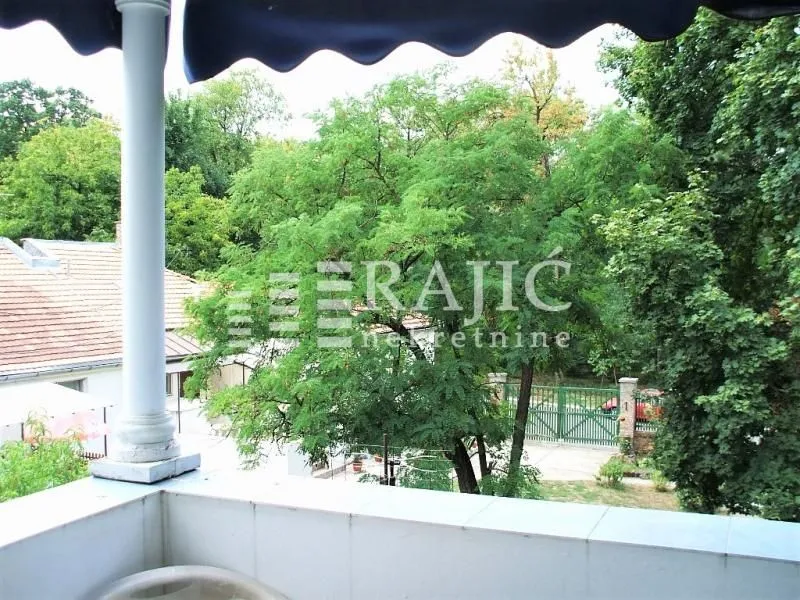 Pogled sa terase na zeleno dvorište i okolne objekte.