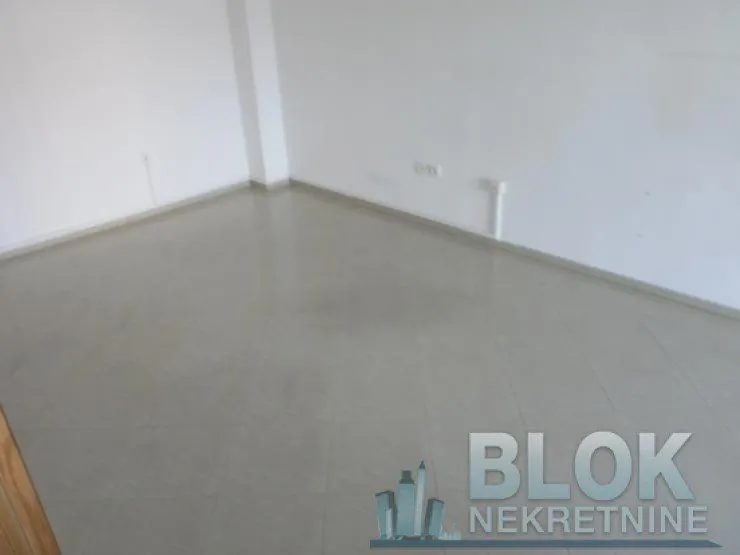 Empty room with white walls and tiled floor.