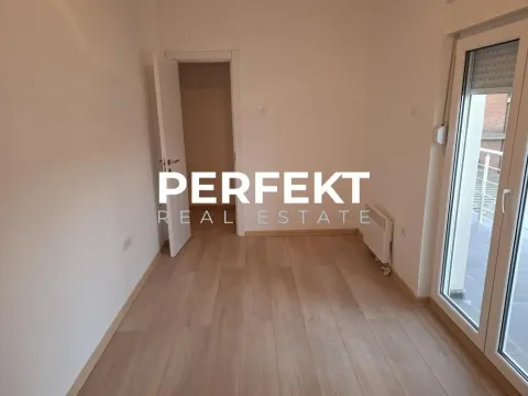 Prazna soba sa parketom i balkonskim vratima. - image 2