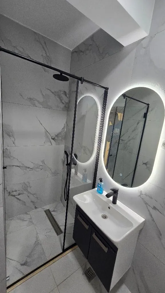 Modernly decorated bathroom with a walk-in shower and vanity.