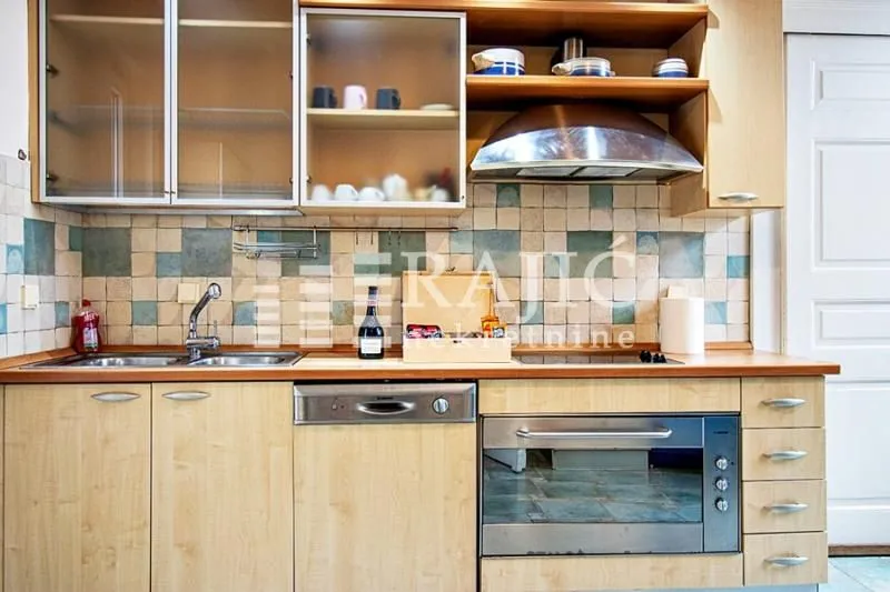 Kitchen with wooden cabinetry and built-in appliances.