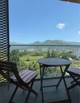 Furnished balcony with a table, chairs, and a view of nature and mountains. - image 7