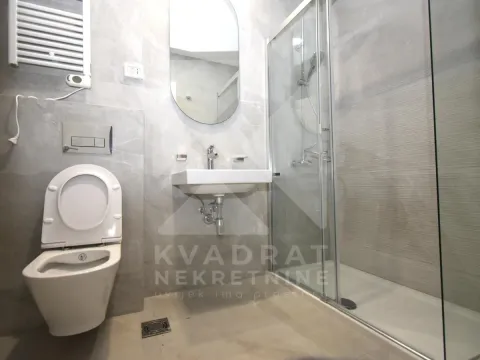 Moderno opremljeno kupatilo sa tuš kabinom, umivaonikom i WC šoljom. - image 9
