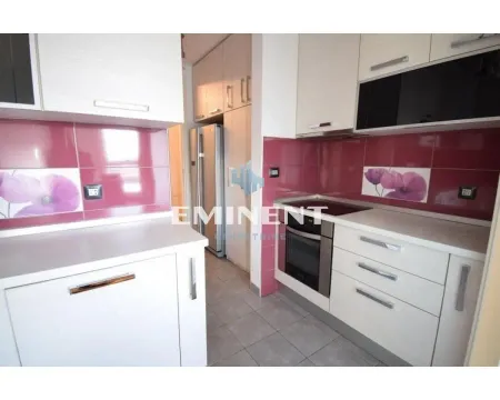 Kitchen with light cabinets and purple wall tiles. - image 6
