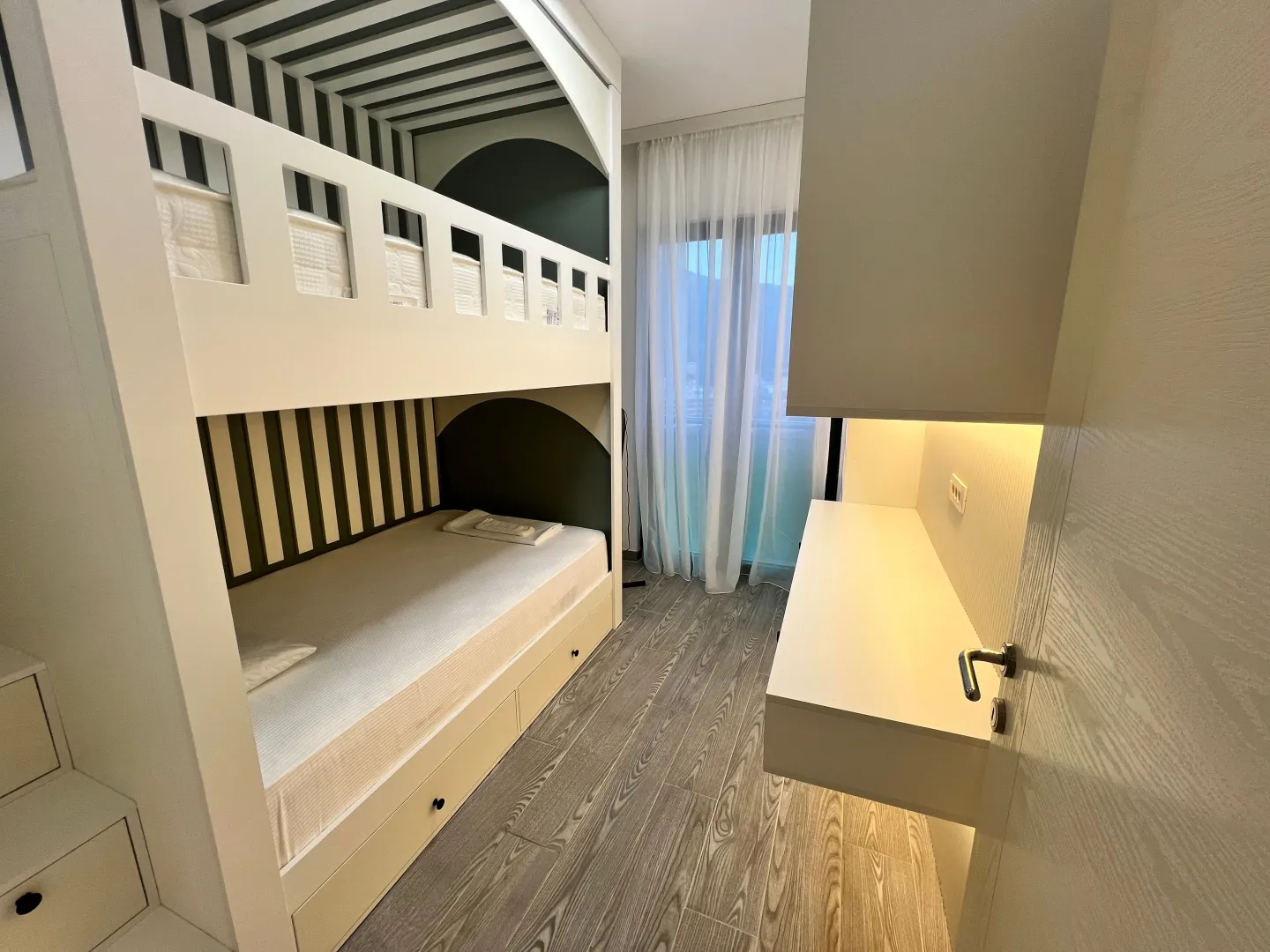 Children's bedroom with a bunk bed and built-in furniture.