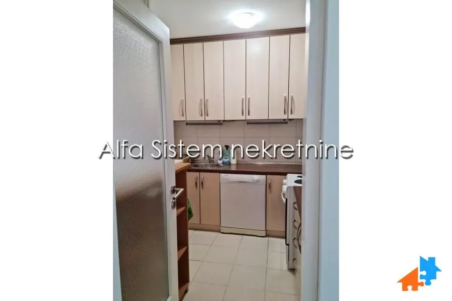 Small kitchen with wooden cabinetry and white goods.