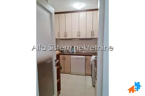 Small kitchen with wooden cabinetry and white goods. - image 14