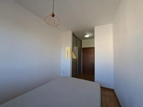 Spavaća soba sa krevetom, ugradnim plakarom i vratima na ulazu. - image 10