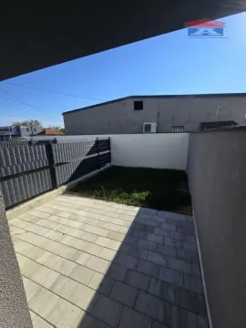 Manje popločano dvorište sa travnatom površinom i ogradom. - image 5