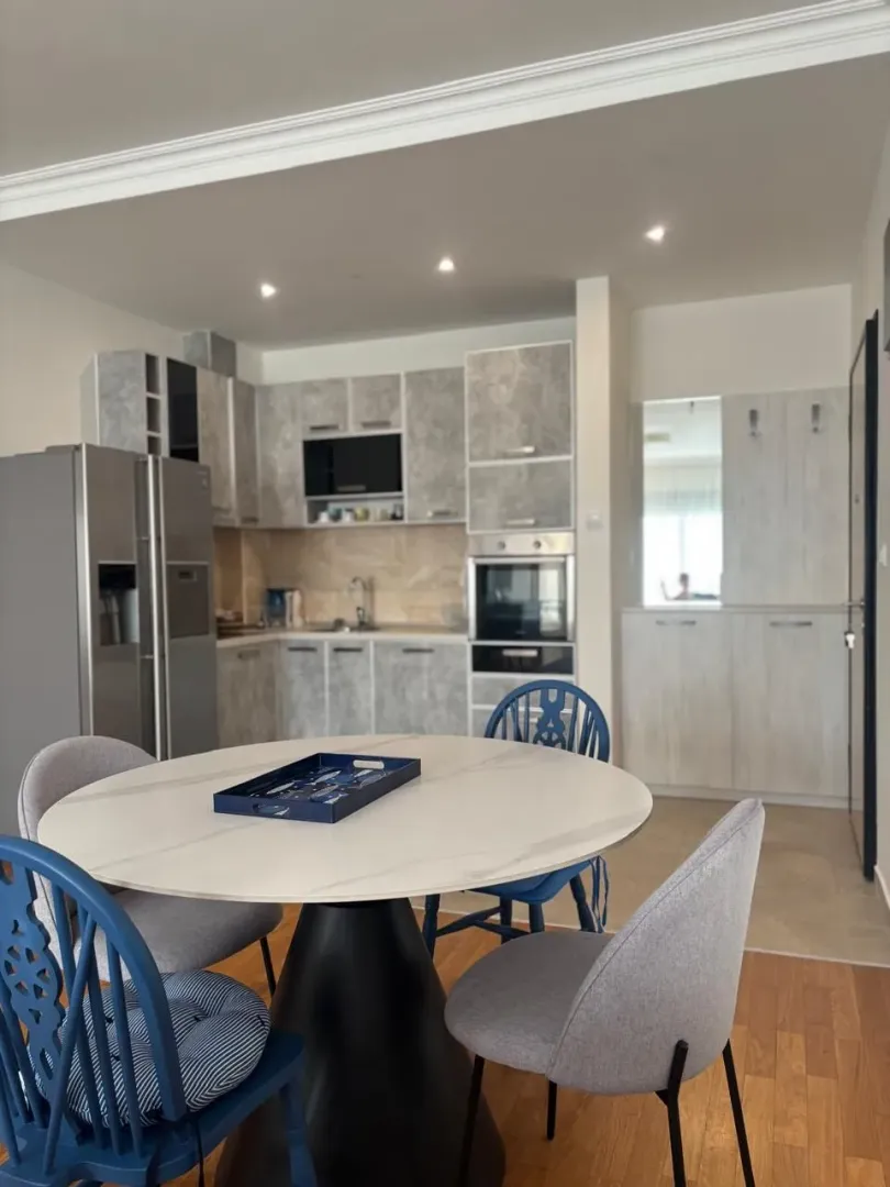 Modern kitchen with a dining table and grey cabinets.