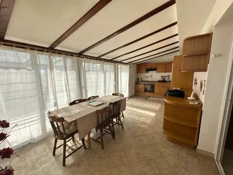 Spacious dining area with a wooden table and chairs, connected to the kitchen. - image 6