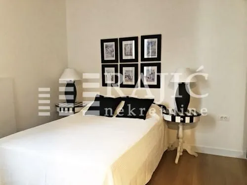 Decorated bedroom with a double bed, bedside tables, and lamps.