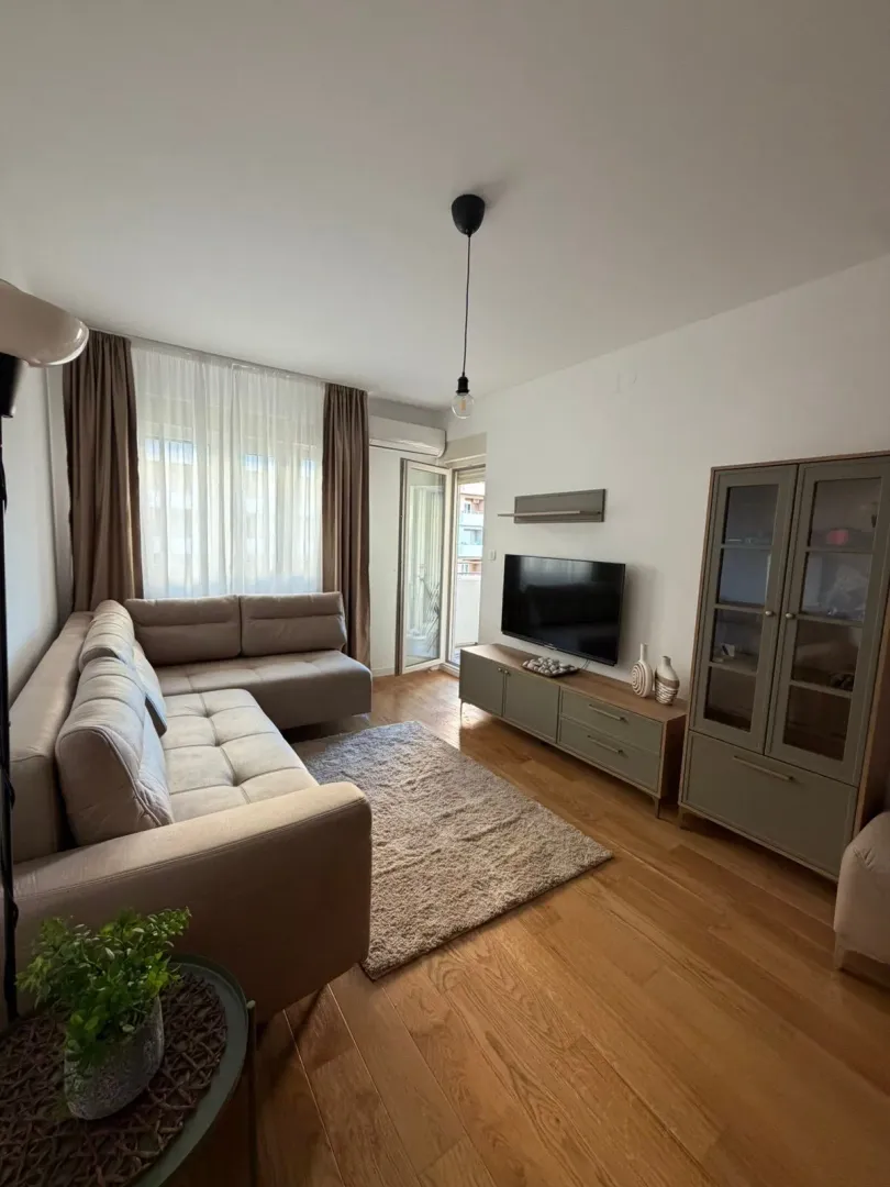 Living room with a sofa, TV, and access to the terrace.