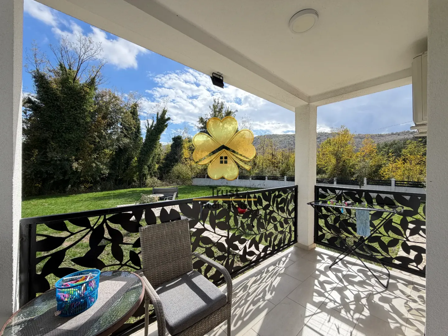 Covered terrace with seating furniture and a view of the green courtyard.