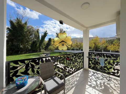 Covered terrace with seating furniture and a view of the green courtyard. - image 15