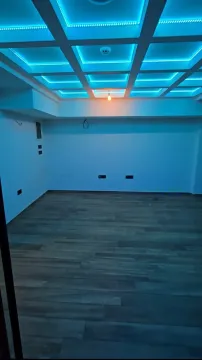 Empty room with a suspended ceiling and blue LED lighting. - image 7