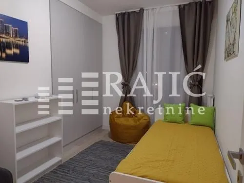 Small bedroom with a bed, wardrobe, and window.