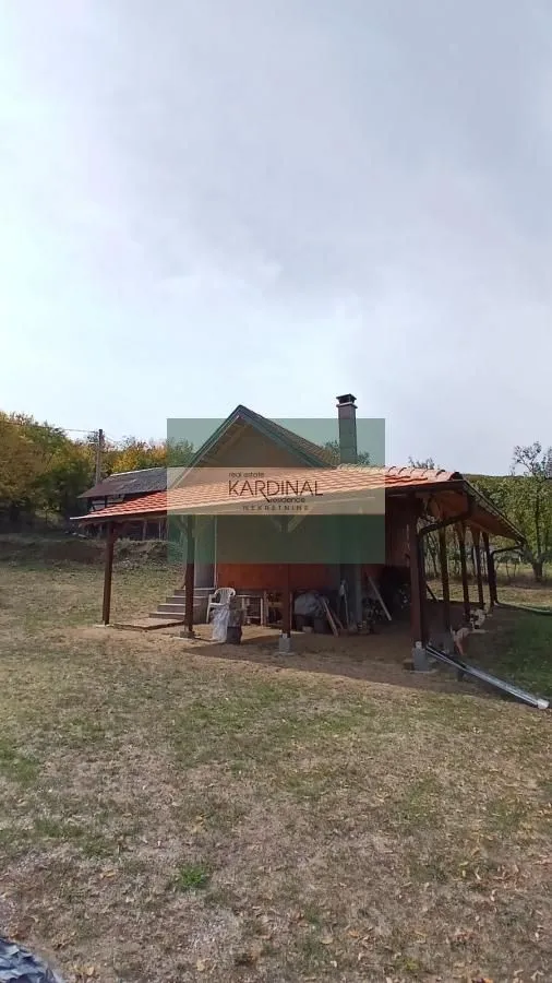 Pogled na spoljašnjost kuće sa natkrivenom terasom i dvorištem.