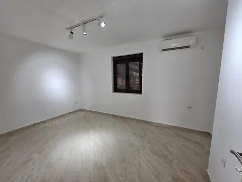 An empty, bright room with light tiled flooring and an air conditioning unit. - image 6
