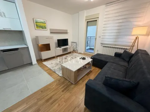 Living room with a sofa, TV, and access to the balcony. - image 8