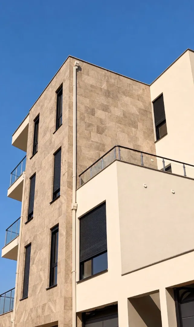 Pogled na spoljašnjost moderne stambene zgrade sa terasama.