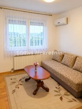 Living room with a sofa, coffee table, and air conditioning. - image 8