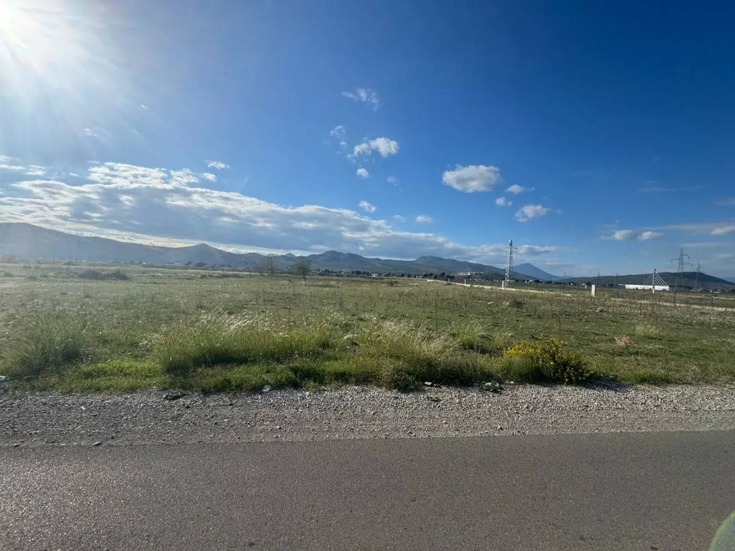 Pogled na ravno zemljište i okolni pejzaž sa planinama u pozadini.