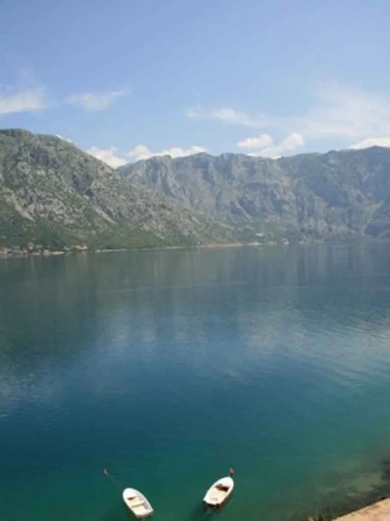 Prelijep pogled na zaliv i planine sa čamcima u vodi.