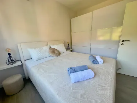 A tidy bedroom with a double bed, wardrobe, and folded towels. - image 7