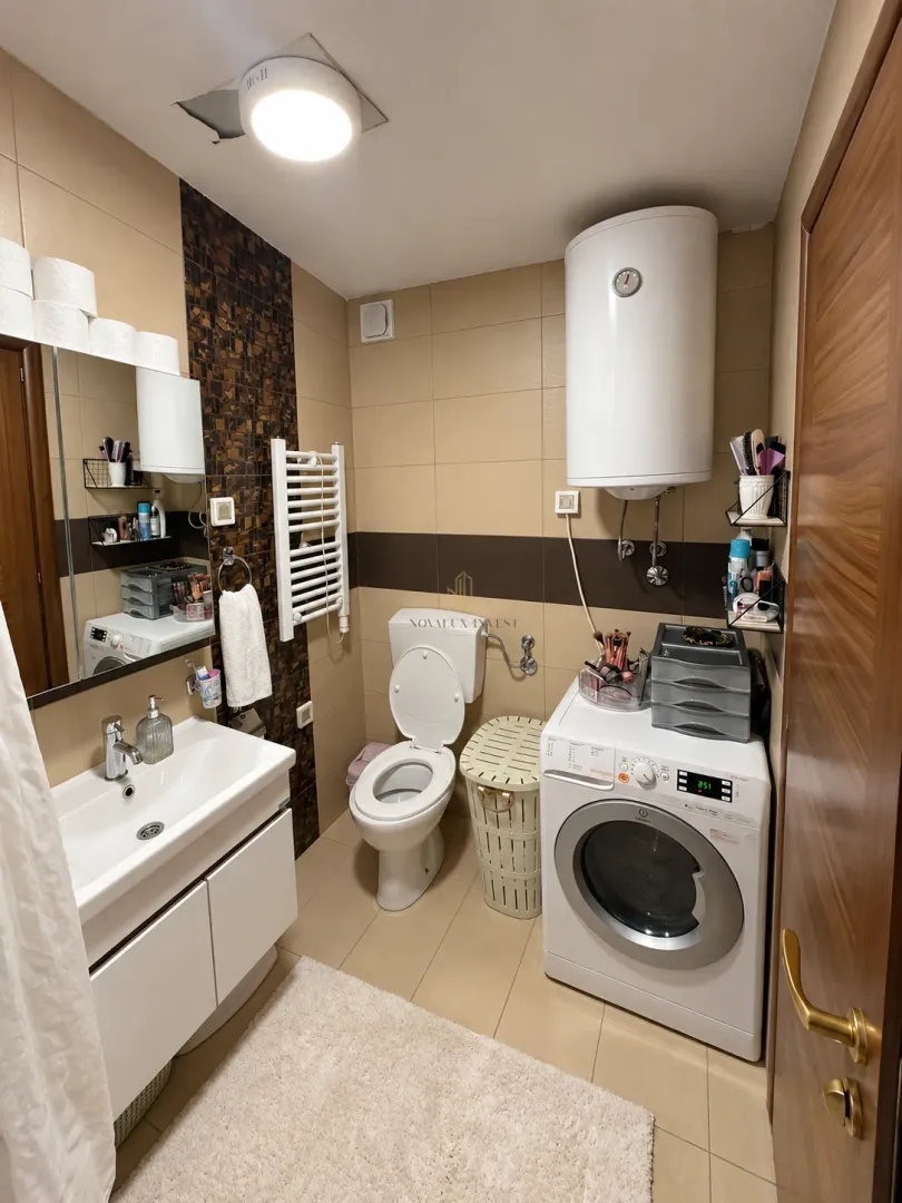 Kompaktno kupatilo sa umivaonikom, WC šoljom, mašinom za veš i bojlerom.