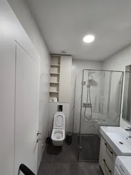 Savremeno opremljeno kupatilo sa tuš kabinom, umivaonikom i toaletom. - image 4