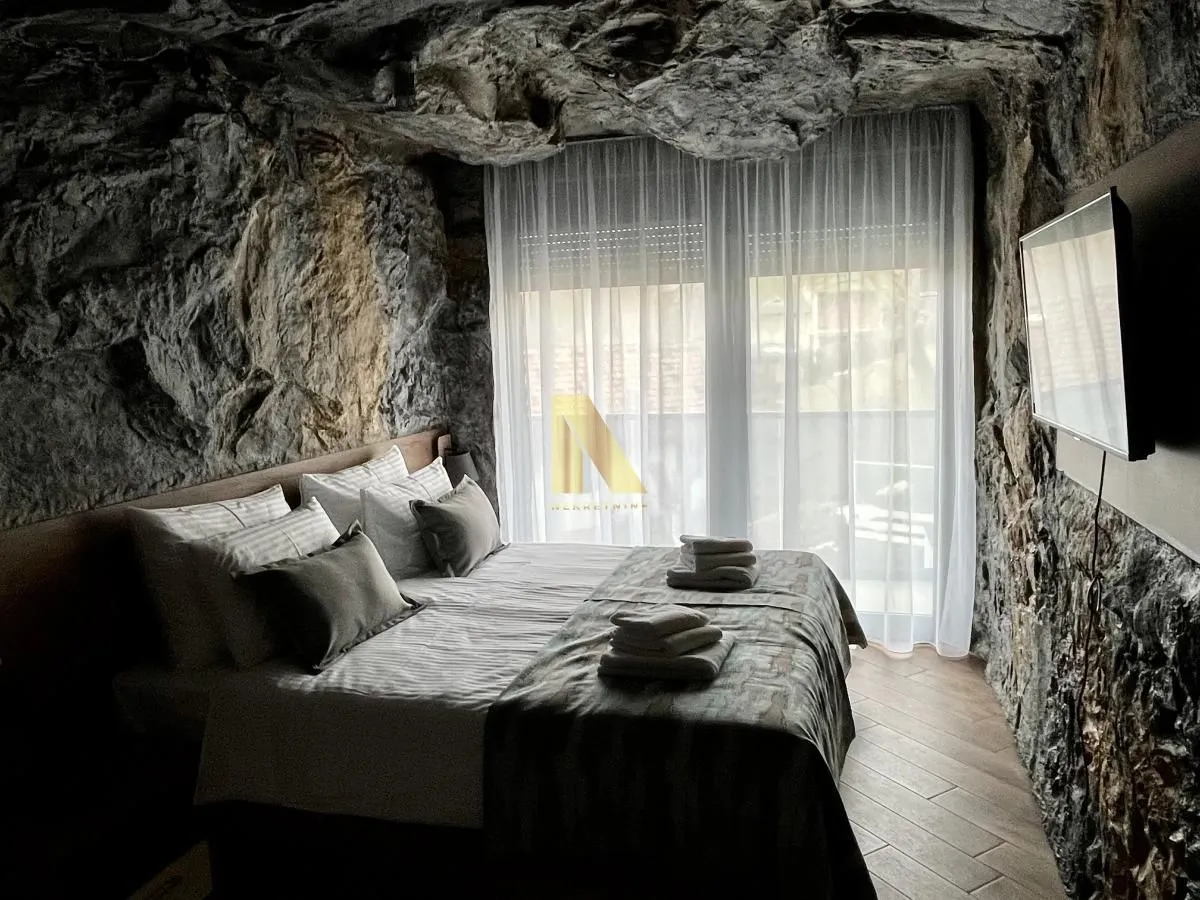 Bedroom with a double bed and natural stone walls.