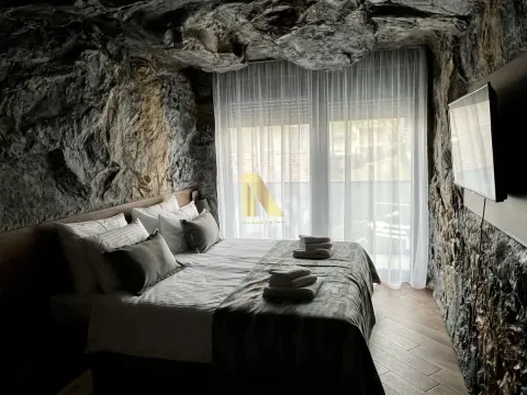 Bedroom with a double bed and natural stone walls. - image 4
