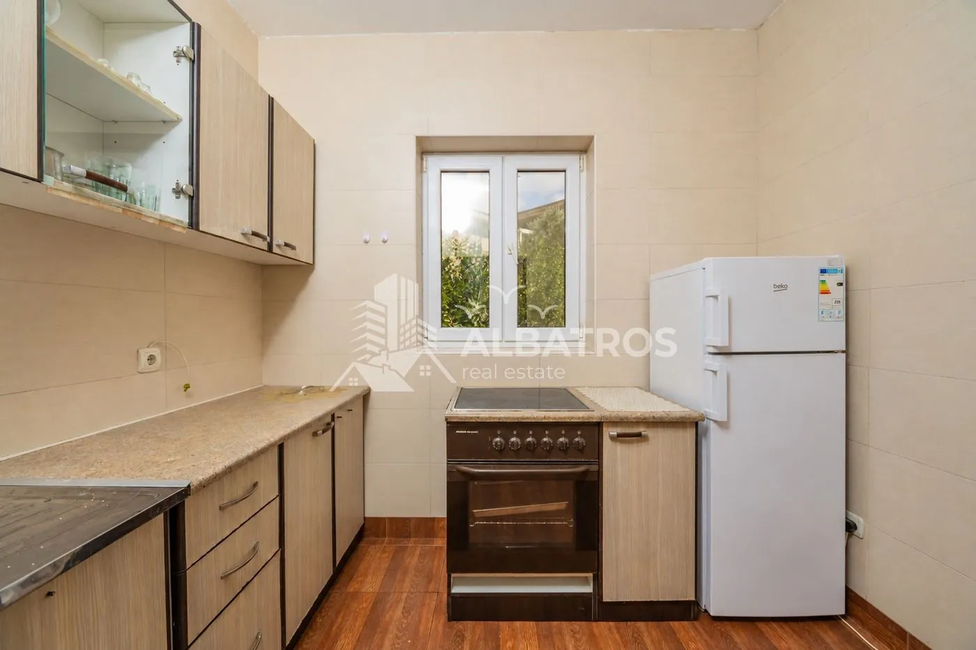 Small kitchen with wooden cabinets, a stove, and a refrigerator.