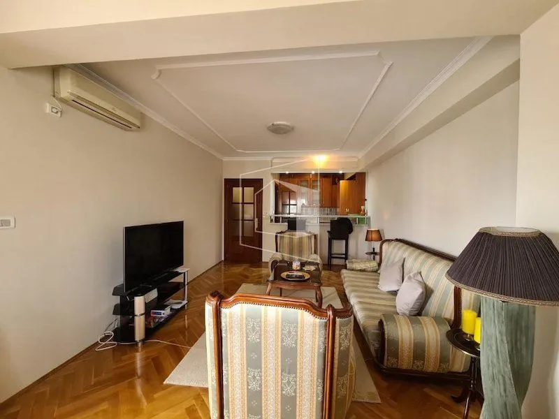 Living room with furniture and a view towards the kitchen.