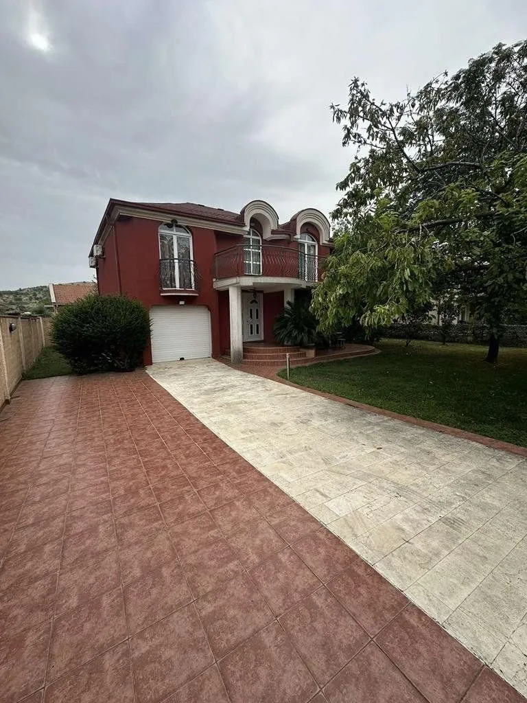 View of the courtyard and house facade with a paved driveway and garage.