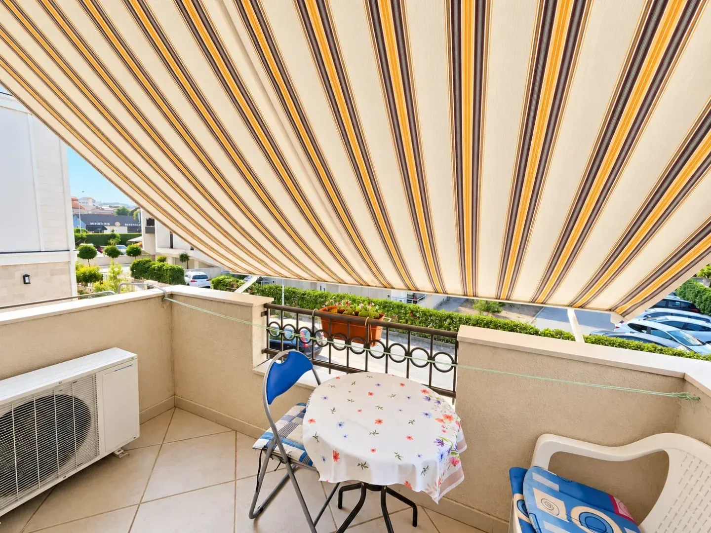 Namješten balkon sa tendom, stolom i stolicama.