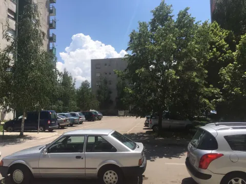 View of the parking lot in front of the residential building with trees. - image 15
